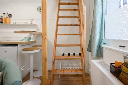 - une échelle en bois dans une cuisine à côté d'un bureau dans l'établissement Studio fonctionnel au coeur de Lille avec parking, à Lille