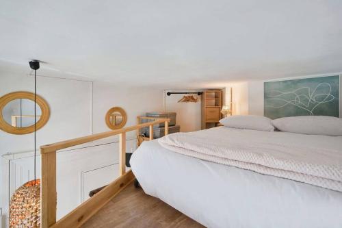 une chambre avec un lit blanc et un miroir dans l'établissement Studio fonctionnel au coeur de Lille avec parking, à Lille