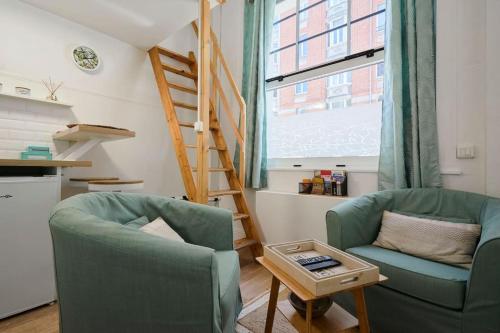 2 chaises et une table dans une pièce avec une échelle dans l'établissement Studio fonctionnel au coeur de Lille avec parking, à Lille