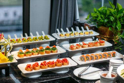 a buffet with several dishes of food on display at MAY DE VILLE Lakeside Hotel in Hanoi
