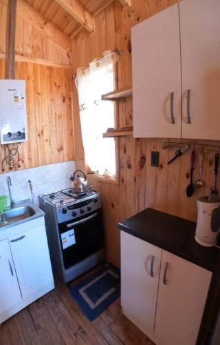 uma pequena cozinha com um fogão e um lavatório em Cabañas Polymar el Tabo em El Tabo