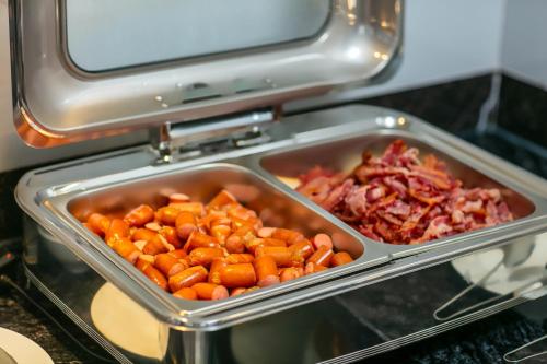 a tray of carrots and other food in an oven at MAY DE VILLE Lakeside Hotel in Hanoi