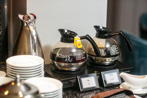 a table with tea pots and dishes on it at MAY DE VILLE Lakeside Hotel in Hanoi