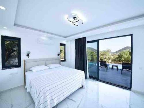 Un dormitorio blanco con una cama y una ventana grande. en Villa Mi Kasa, en Kas