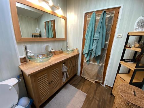 La salle de bains est pourvue de 2 lavabos et d'un miroir. dans l'établissement Gite la Maison de la Pimpine Lignan de Bordeaux, à Lignan-de-Bordeaux