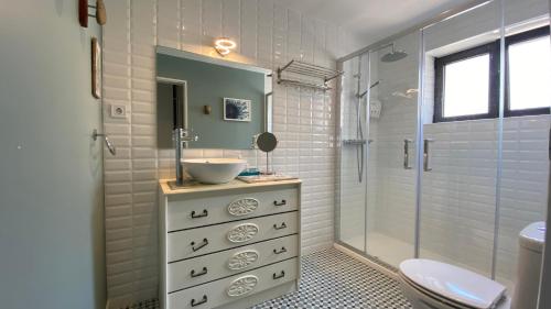 uma casa de banho com um lavatório e uma cabina de duche em vidro. em Sea Ceiling - Ericeira na Ericeira