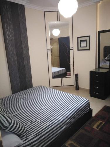 a bedroom with a black and white striped bed and a mirror at Hurghada British compound in Hurghada