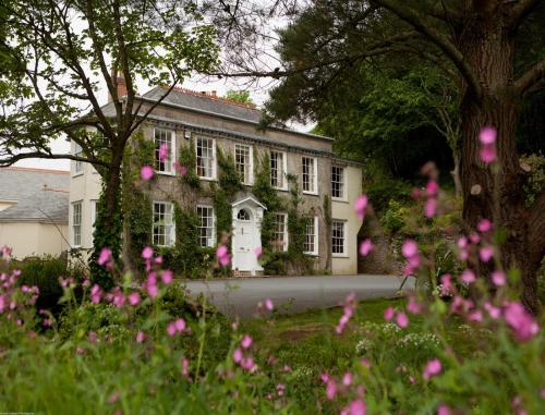 una casa con fiori rosa davanti di Rose in Vale Country House Hotel a St. Agnes 