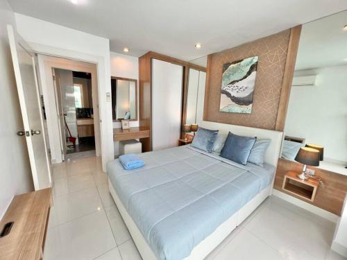 a bedroom with a large bed with blue pillows at Blissful 1 Bed in Amazon Condo in Jomtien Beach