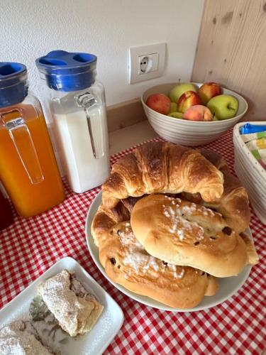 a table with a plate of bread and a bowl of apples at La locanda di Geppetto in Bedollo