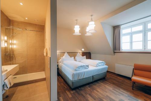 a bedroom with a bed and a shower and a bathroom at Hotel Amalia - Boutique Hotel in Landshut