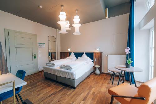 1 dormitorio con 1 cama, mesa y sillas en Hotel Amalia - Boutique Hotel en Landshut