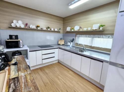 a kitchen with white cabinets and a sink at Doldamine Jeju in Jeju