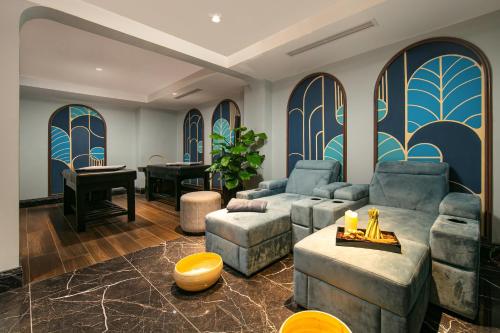 a living room with two couches and a piano at MAY DE VILLE Lakeside Hotel in Hanoi