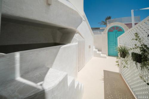 a white building with a blue door and a staircase at Marla Luxury Residences in Megalokhori