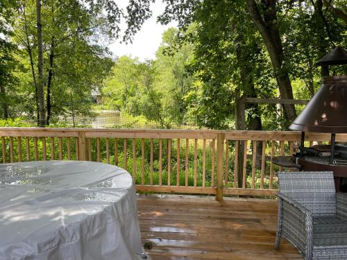 une terrasse en bois avec une table et une clôture dans l'établissement Creekside Fantasy Inn, à Hudson