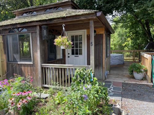 a wooden shed with a porch and a door at Creekside Fantasy Inn in Hudson