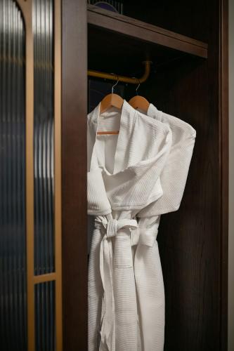 a white robe is hanging on a door at MAY DE VILLE Lakeside Hotel in Hanoi