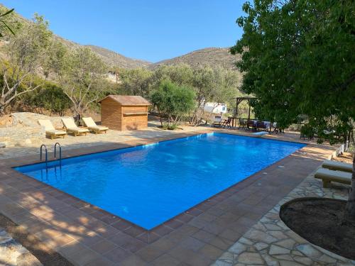 a swimming pool with blue water in a yard at Apaggio Apartments in Katapola