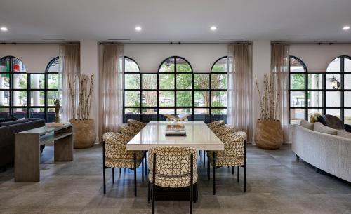 a dining room with a table and chairs and windows at The Siena Hotel, Autograph Collection in Chapel Hill