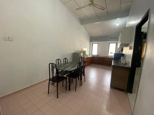 ein Esszimmer mit einem Tisch und Stühlen sowie eine Küche in der Unterkunft Best Homestay in Kuala Rompin