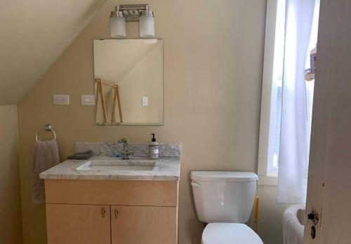 a bathroom with a toilet and a sink and a mirror at Modern Cottage Two (The Lorca, Catskills) in Shandaken