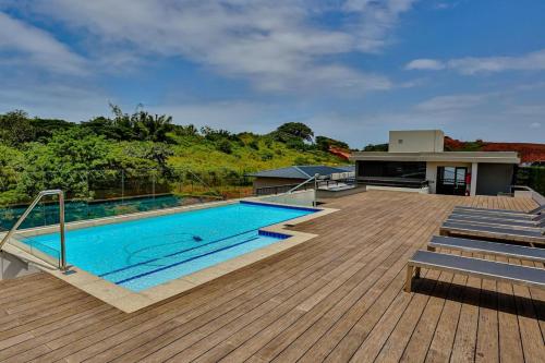 a swimming pool on top of a wooden deck at Zimbali Lakes Boulevard Suites Studio Apartments in Ballito