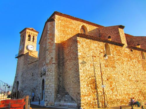 a large brick building with a clock tower on it at Cocoon'in Cannes Le Suquet in Cannes