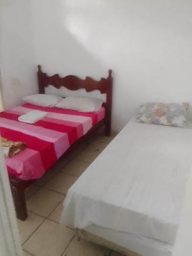 - une chambre avec 2 lits dotés de draps rouges et blancs dans l'établissement Pousada Garcia, à São Paulo