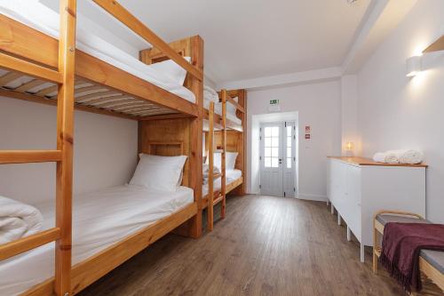 ein Schlafzimmer mit Etagenbetten in einem Hostel in der Unterkunft Jardim das Camélias in Madalena