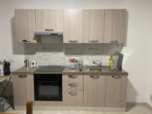 a kitchen with wooden cabinets and a sink at Villetta 2 piani in Borgo Ticino