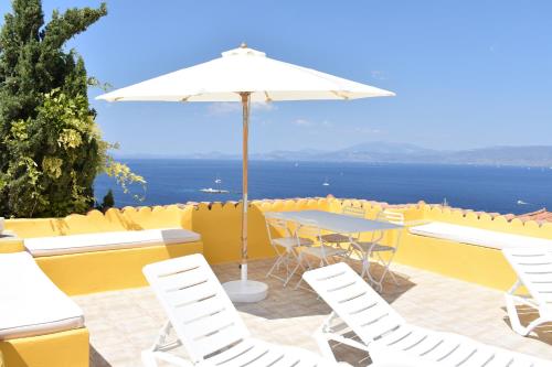 a patio with a table and chairs and an umbrella at Chez Le Goff in Hydra