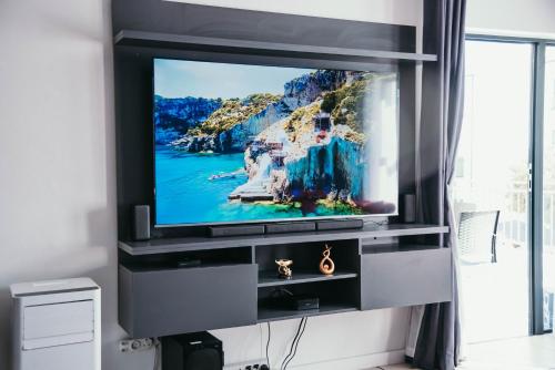 a flat screen tv in a entertainment center at Sizakele Stays in Johannesburg