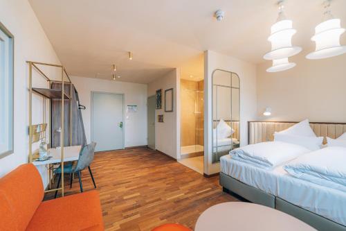 a bedroom with a bed and a desk and a room at Hotel Amalia - Boutique Hotel in Landshut