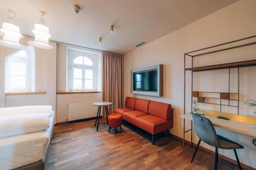 a hotel room with a bed and a couch and a table at Hotel Amalia - Boutique Hotel in Landshut