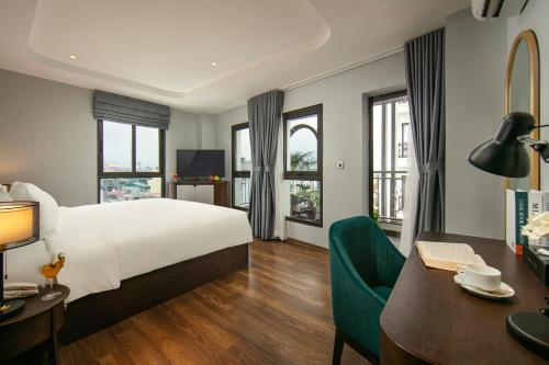 a hotel room with a large bed and a desk at MAY DE VILLE Lakeside Hotel in Hanoi
