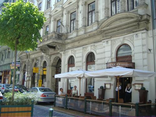 een restaurant met witte parasols voor een gebouw bij City Rooms in Boedapest