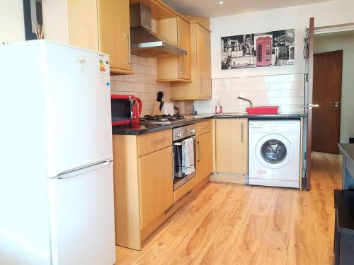 een keuken met een koelkast en een wasmachine bij Cosy Studio Flat in Great Locationin London in Londen