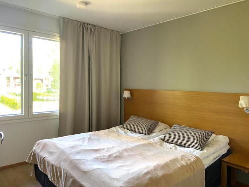 - une chambre avec 2 lits et une fenêtre dans l'établissement Kylpyla SPA, lake saimaa villa, à Imatra