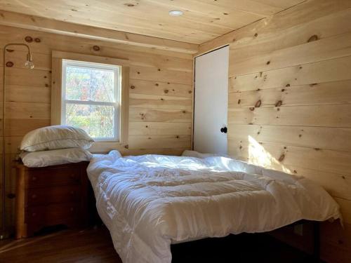 um quarto com uma cama num chalé de madeira em Stream House (The Lorca, Catskills) em Shandaken