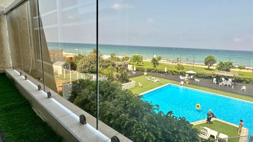 a view of a swimming pool and the ocean from a building at Gugel Waves Apartments GW208 in Nahariyya