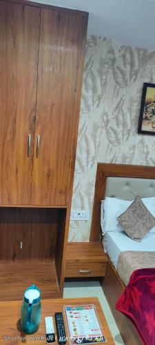 a bedroom with a bed and a wooden cabinet at Hotel Siddhi Vinayak in Jodhpur