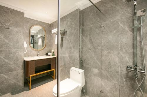 a bathroom with a shower and a toilet and a sink at MAY DE VILLE Lakeside Hotel in Hanoi