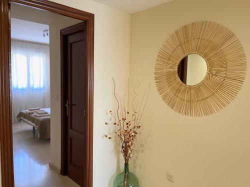a mirror and a vase with flowers in a room at Wallada Vistalegre in Córdoba