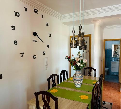 a dining room with a table and a clock on the wall at Oualidia29 in Oualidia