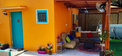 Casa colorida con sofá en el patio en בית הלב en Nahariyya