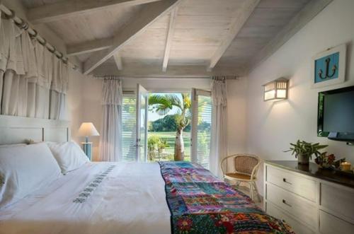 ein Schlafzimmer mit einem großen weißen Bett und einem Fenster in der Unterkunft Sunny Vacation Villa No 94 in San Rafael del Yuma