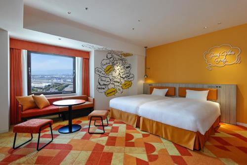 a hotel room with a bed and a table and a window at Hotel Kintetsu Universal City in Osaka