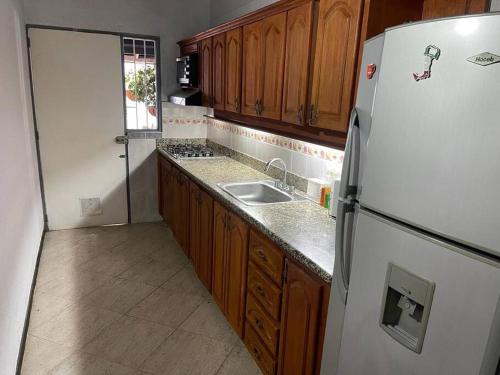 uma cozinha com um frigorífico branco e um lavatório em Casa en el corazón de Rionegro! em Rionegro