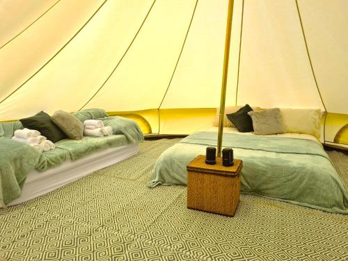 two beds in a room with a tent at Boyce Fen Farm Retreat Glamping & Fishery in Wisbech